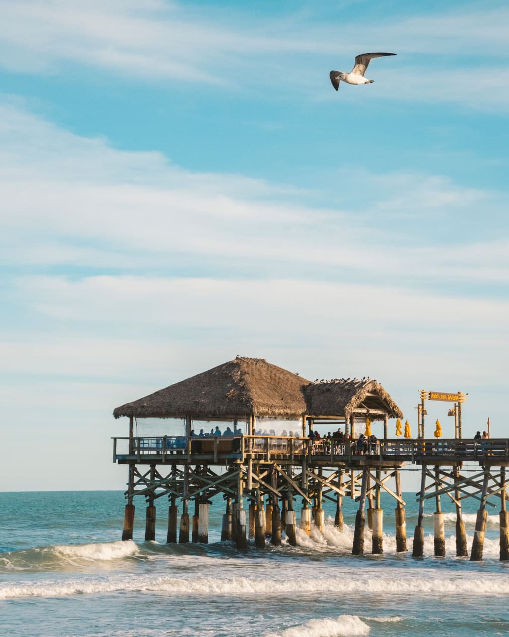 Pier pavilion over the waves under a blue sky